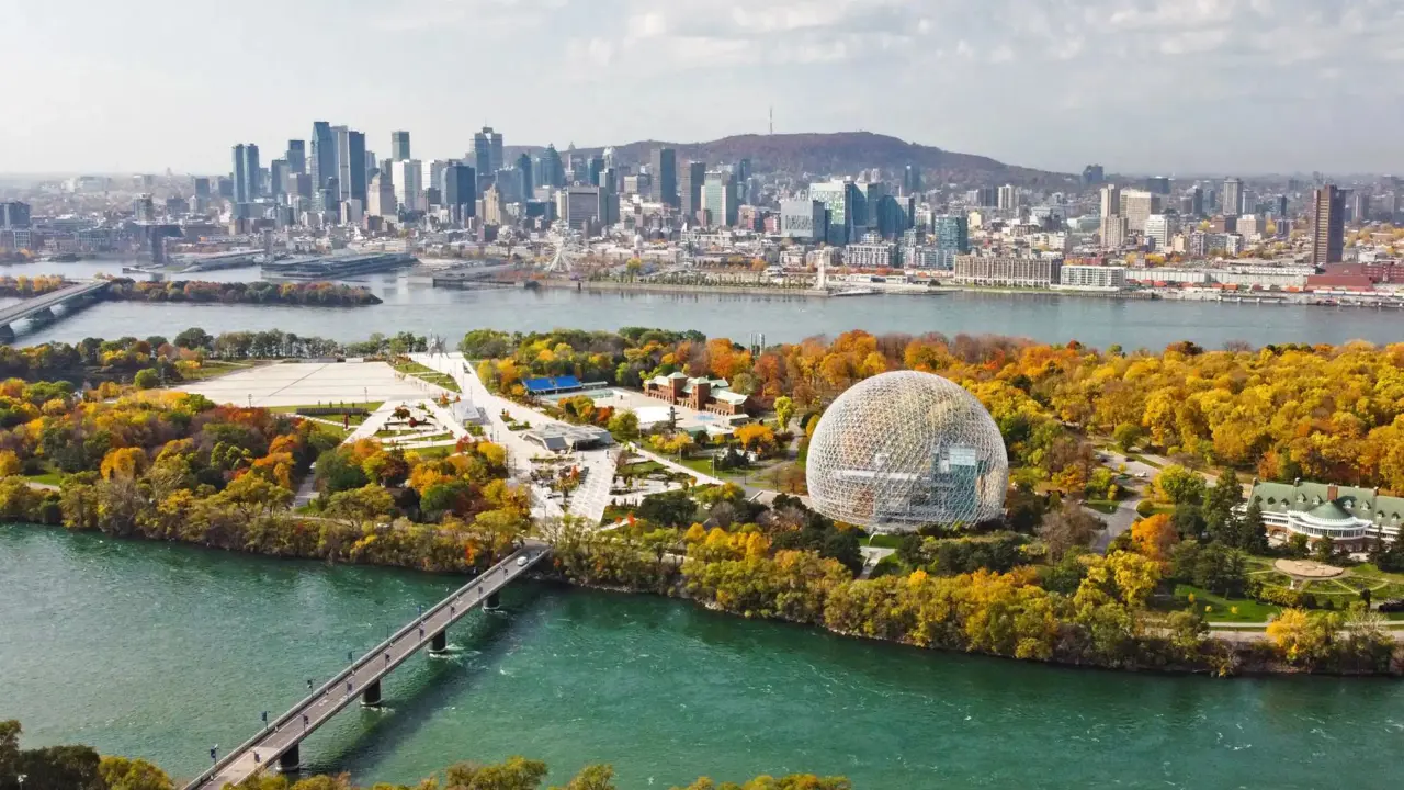 Aerial view of Montreal with the Biosphere and city skyline, surrounded by colourful autumn foliage and the St. Lawrence River