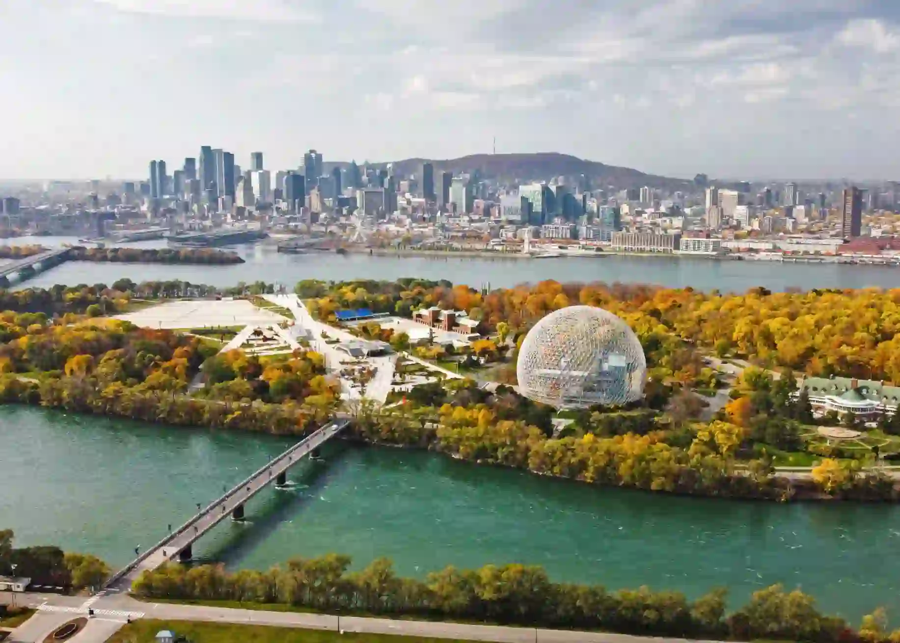Aerial view of Montreal with the Biosphere and city skyline, surrounded by colourful autumn foliage and the St. Lawrence River