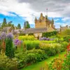 View of Cawdor Castle from the gardens, with colourful flowers and greenery in the forefront