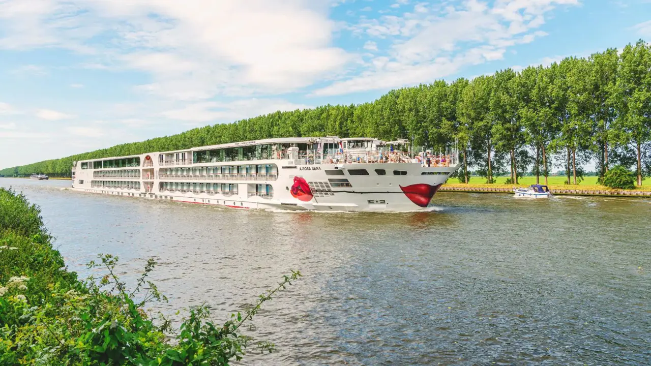 The A-ROSA SENA river cruise ship on a calm river, showcasing its modern exterior against a scenic backdrop