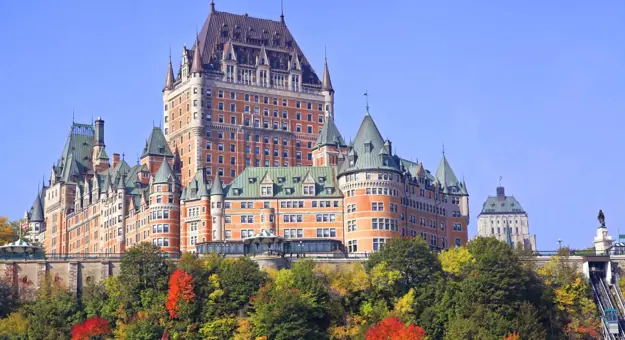 The Château Frontenac, a grand historic hotel in Quebec City, Canada, with its distinctive steep green roofs and turrets against a clear sky