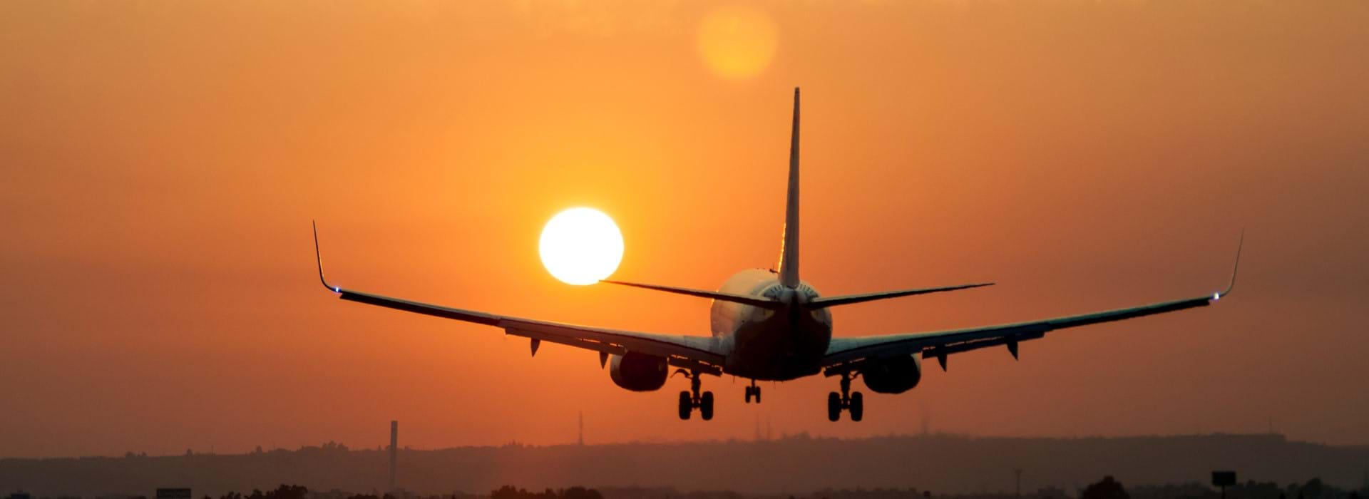 Airplane landing at sunset 