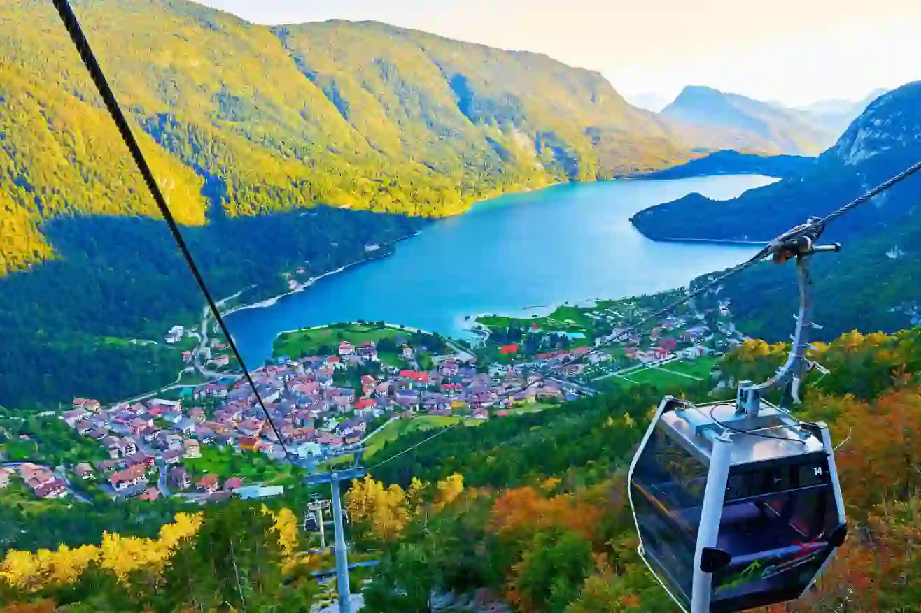 High angle view of the village of Molveno and Lake Molveno in Italy with a cable car in the forefront and the Dolomites in the background
