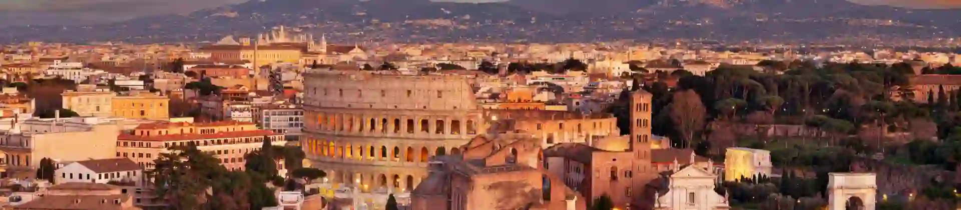 Cityscape of Rome at sunset, showing the Colosseum and St. Peter's Basilica