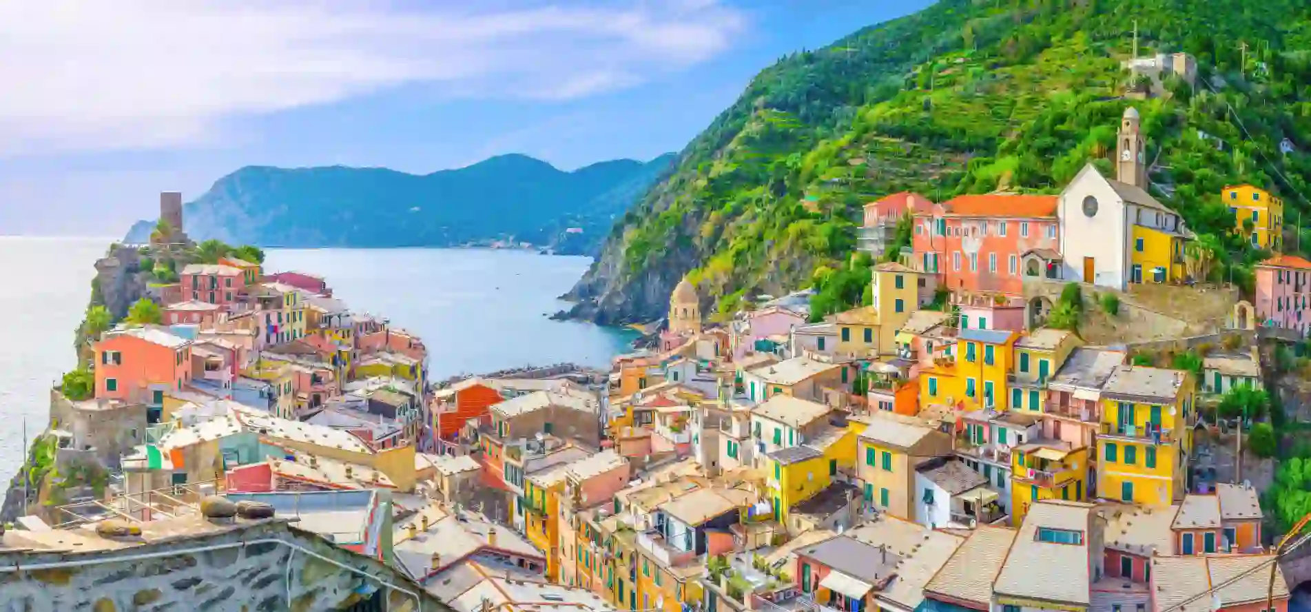 Scenic view of Vernazza, a colourful coastal village in Cinque Terre, with blue sea and a mountains in the distance