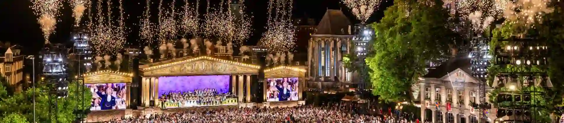 André Rieu performing live in Maastricht's Vrijthof square whilst fireworks light up the sky above the stage