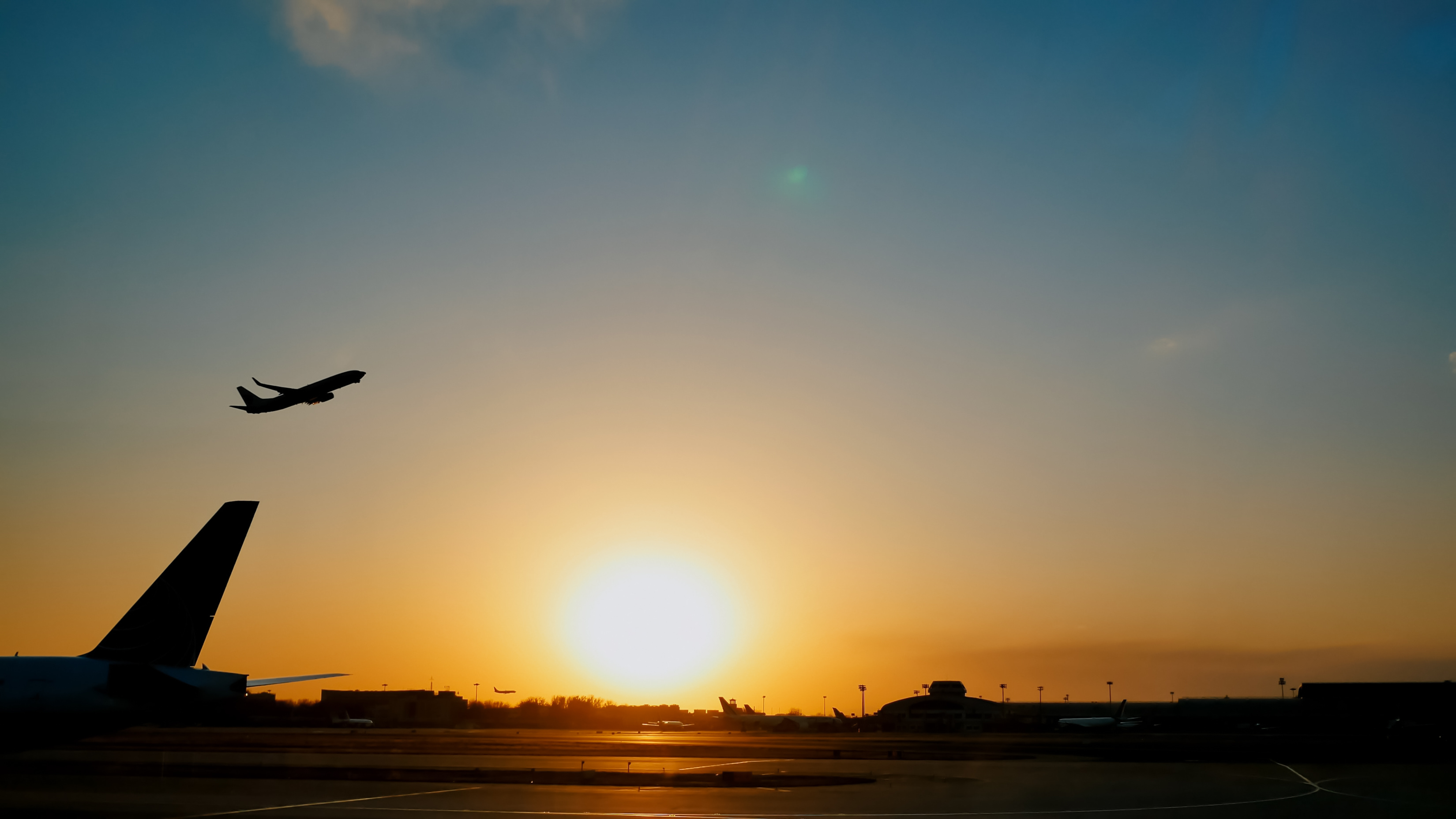 Airplane taking off at sunset over an airport 
